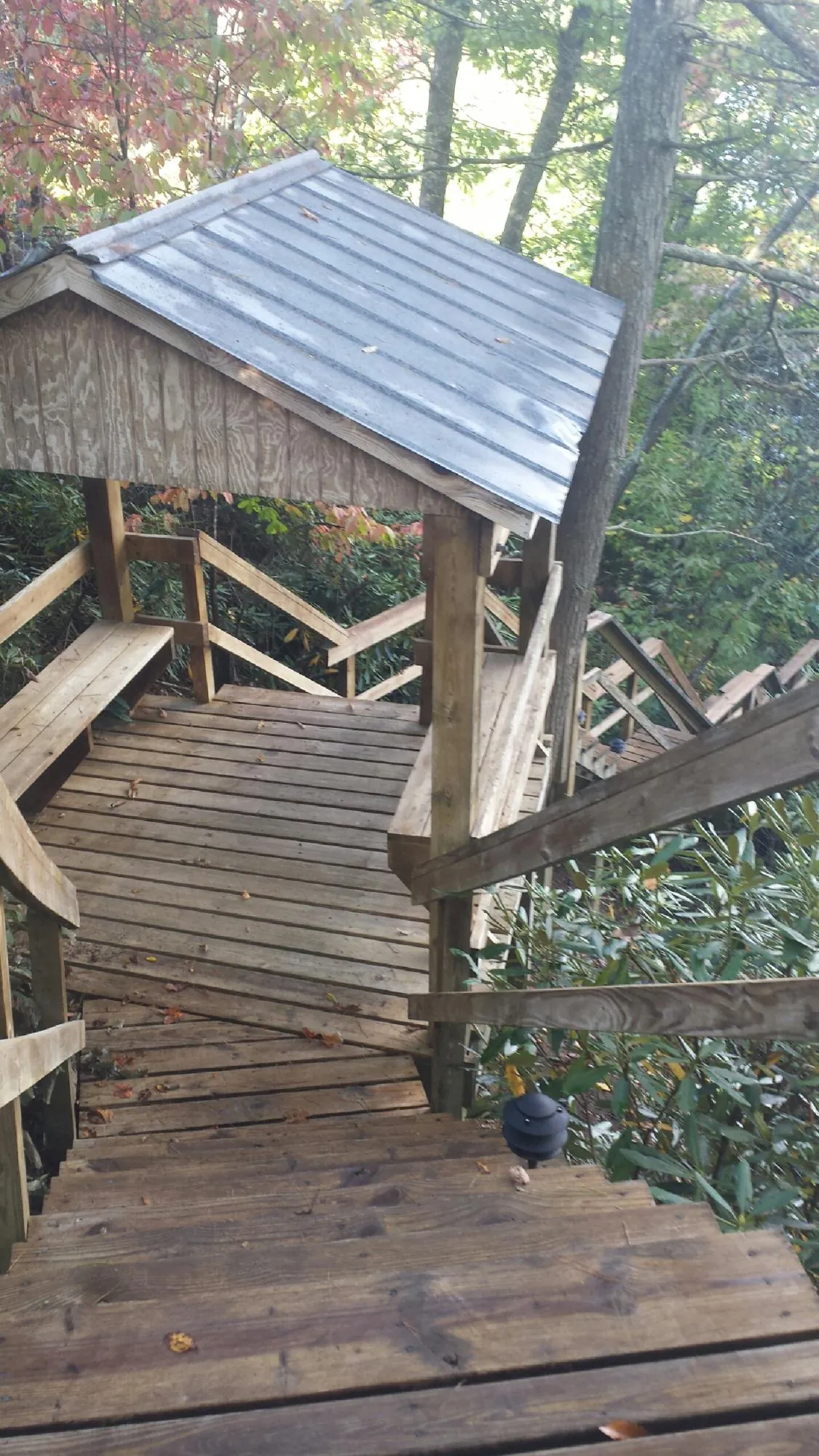 Metal roofed shelter over wooden steps on a wooded walkway — Skylight Repair & Installation work by our crew in Vincent