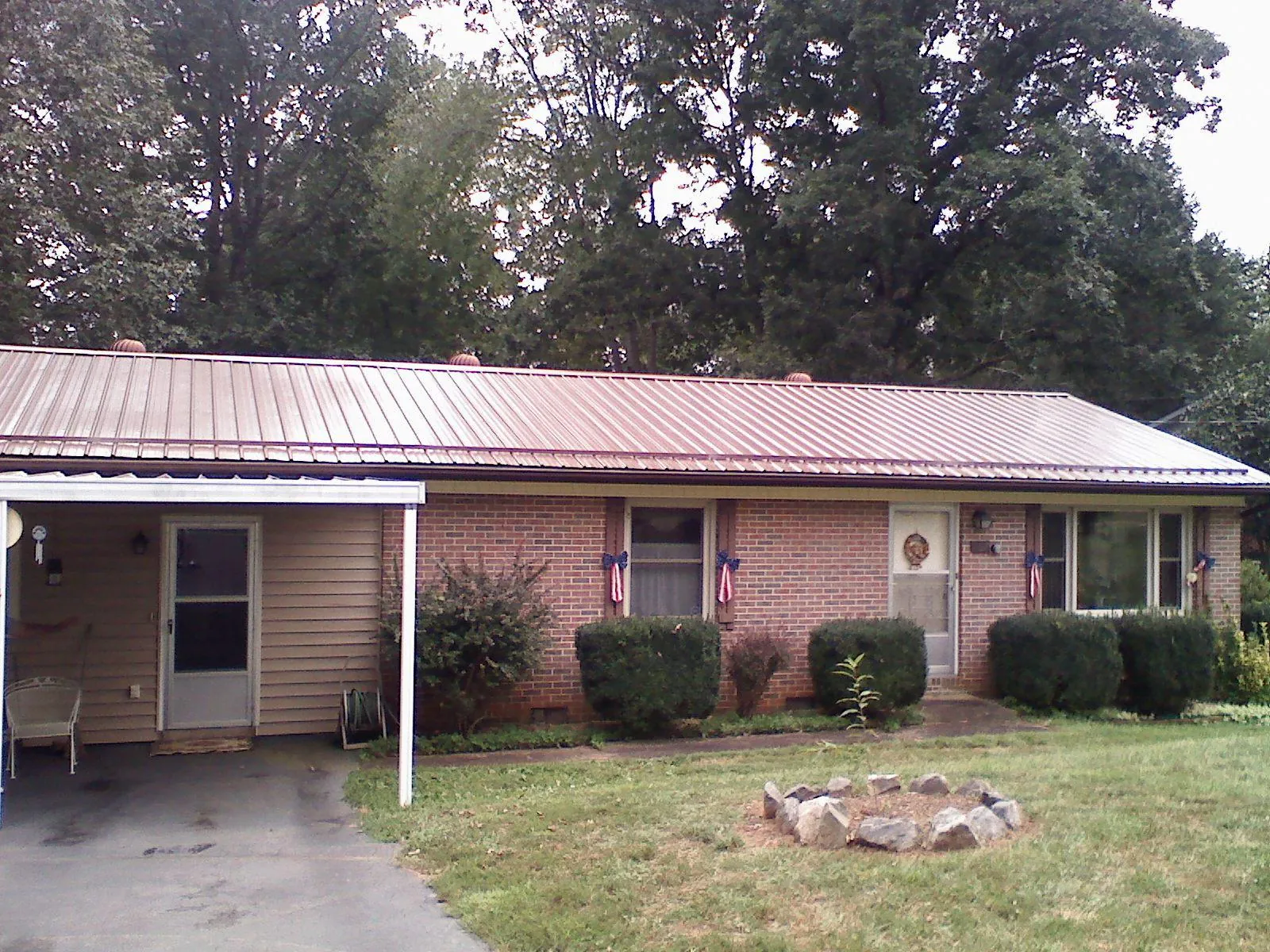 Bronze metal roof and carport on a brick ranch home — Roof Repair work by our crew in Vincent