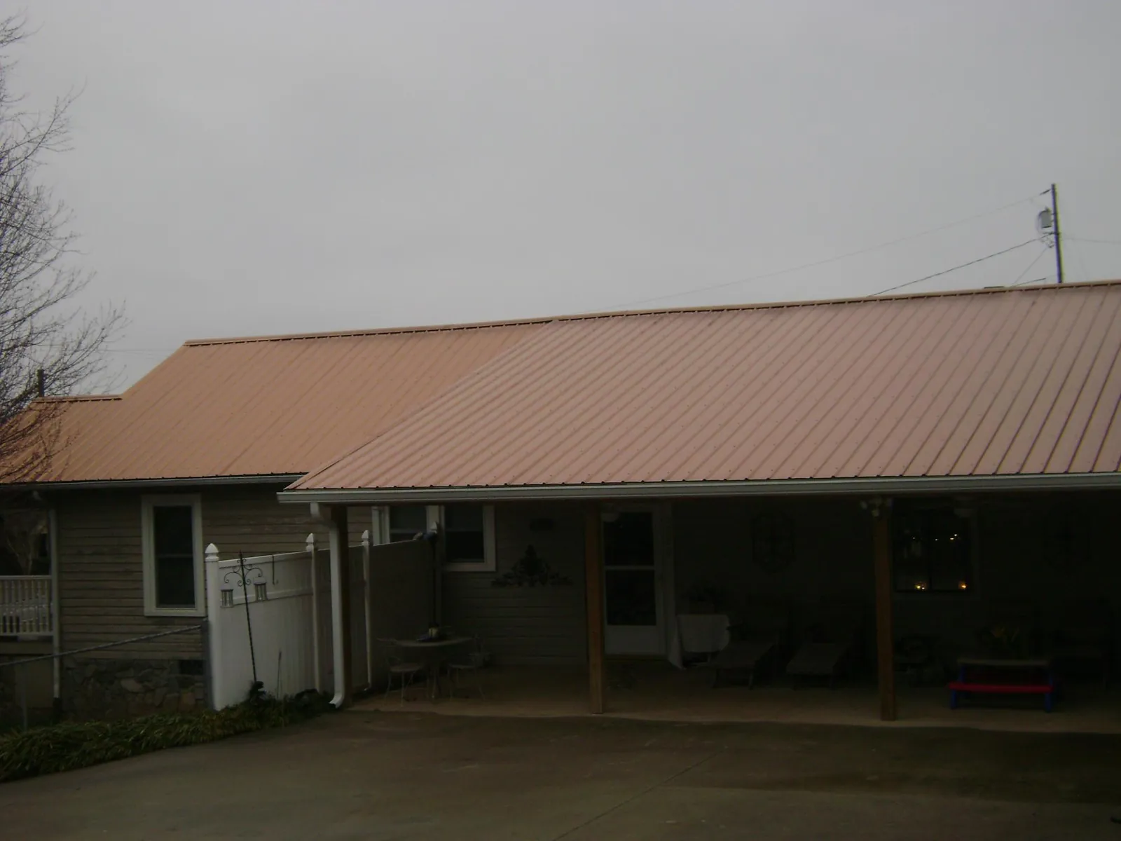 Copper toned metal roof over a wide covered patio in Vincent